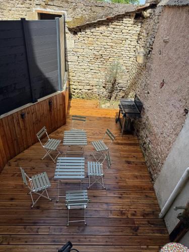 a group of chairs and tables on a wooden deck at Au Petit Langres Logement Centre-Ville in Langres