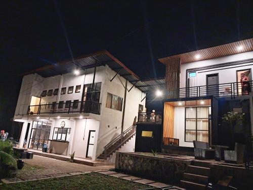a large white building with a balcony at night at Bromo Dormitory in Bromo