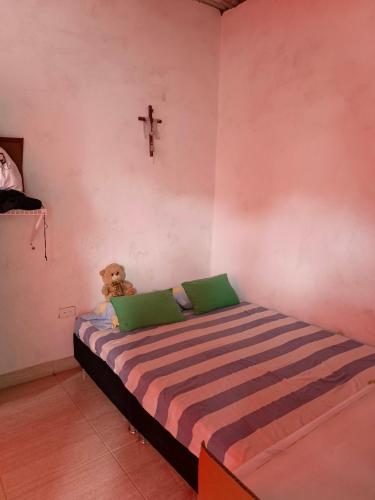 a teddy bear sitting on a bed in a room at Orquídeas Hause in Estación El Salto