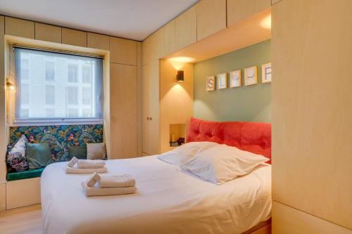 une chambre avec un lit blanc avec des serviettes dessus dans l'établissement Cozy apartment, perfect location, à Bordeaux