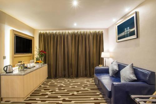 a living room with a blue couch in a hotel room at Metropark Hotel Macau in Macau
