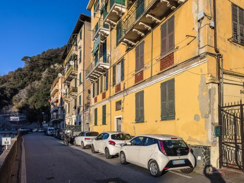 a row of cars parked next to a yellow building at Family Space - Beaches 900m - WiFi - Smart TV in Varazze
