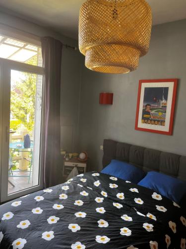 a bedroom with a bed and a window and a chandelier at Cyrus House in Le Mans