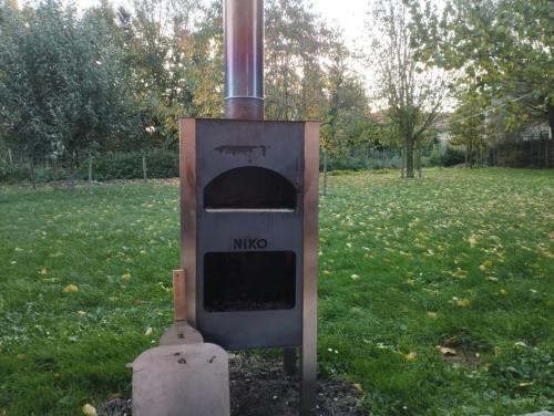 an old oven sitting in the grass in a field at Smishoeve "Huis van de Raaf" in Heers