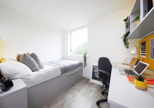 a bedroom with a bed and a desk with a laptop at For Students Only Cathedral Point in Winchester in Winchester
