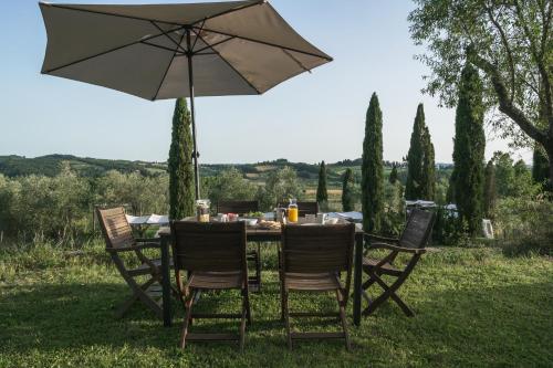 a table with an umbrella in the grass at Agriturismo La Ca'Solare in Palaia