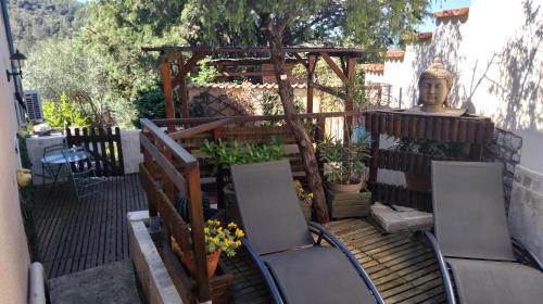 a patio with chairs and a gazebo and a statue at Les Lauriers Roses in Salavas