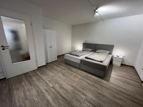 a large room with two beds and a door at 3 Zimmer Standard Apartment - 7 Betten - 2 x Badezimmer in Wolfsburg