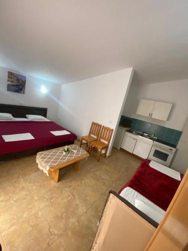 una stanza con un letto, un tavolo e delle sedie di Starlight Apartments a Ulcinj