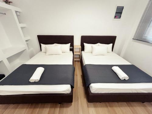 two beds in a small room with black and white at PEDRO NAVARINO II Laganas in Laganas