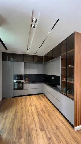a large kitchen with wooden floors and cabinets at MIKU Green Coast in Palasë