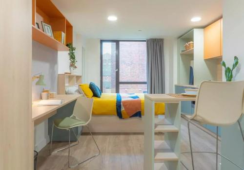 a bedroom with a bed with a yellow and blue blanket at For Students Only iQ Signal Place Nottingham in Nottingham