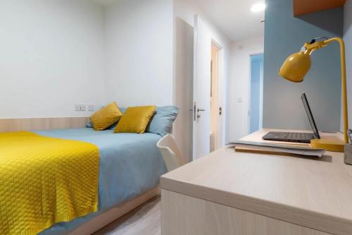 a bedroom with a bed and a laptop on a counter at For Students Only iQ Signal Place Nottingham in Nottingham