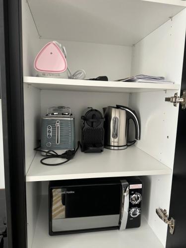 - une étagère avec un four micro-ondes et d'autres articles dans l'établissement Centre Ville - Refait à neuf - Calme - Clim, à Marseille