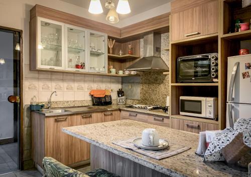 a kitchen with wooden cabinets and a counter top at Casa Eva, rústica y cálida familiar in Asuncion