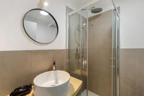 a bathroom with a sink and a shower with a mirror at Le Nene - Dolomiti guesthouse in Pieve di Cadore