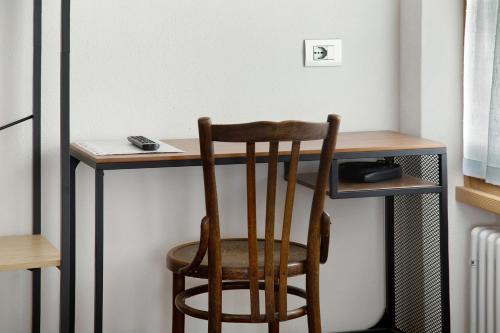 a wooden chair sitting in front of a desk at Le Nene - Dolomiti guesthouse in Pieve di Cadore