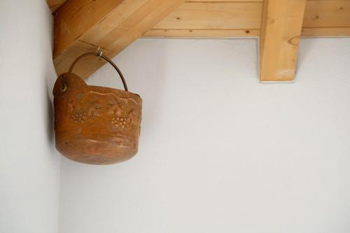 a jug hanging from a beam on a wall at Le Nene - Dolomiti guesthouse in Pieve di Cadore