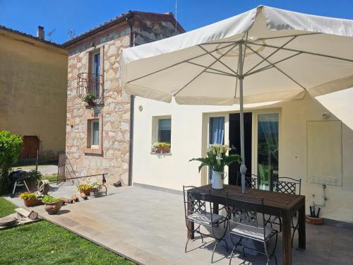 a table with an umbrella on a patio at La Bottega del Maniscalco in Filettole