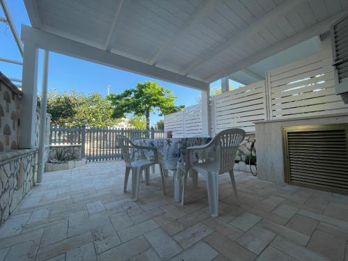 a patio with a table and chairs on a patio at Lo Scrigno in Torre Canne