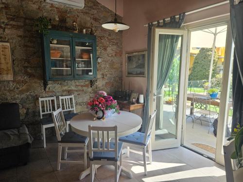 a dining room with a table and chairs and a patio at La Bottega del Maniscalco in Filettole