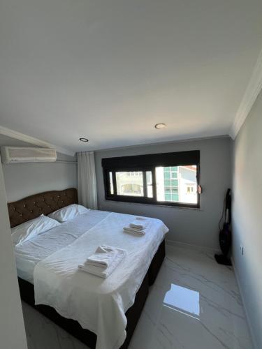 a bedroom with a bed with white sheets and a window at SideByLotus in Side