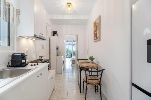 a kitchen with white cabinets and a table with chairs at View of the Ionian Sea, Vournikas in Vournikás