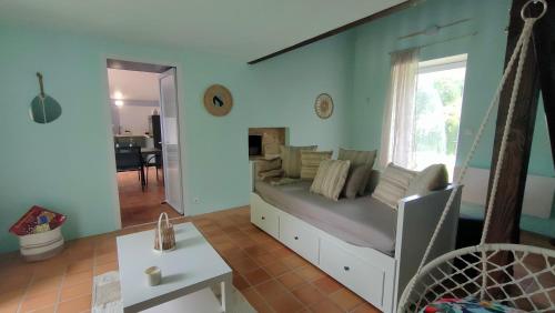 a living room with a bed and a window at Les Murmures de Charente in Villiers-le-Roux