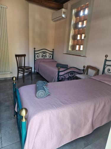 a bedroom with two beds and a window at La Bottega del Maniscalco in Filettole