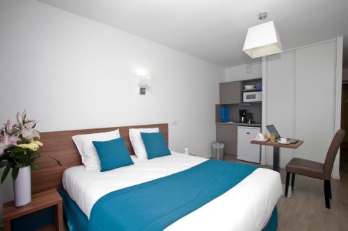リュエイユ・マルメゾンにあるレジデンス オダリス パリ リュエイユのベッドルーム1室(大型ベッド1台、青と白の枕付)