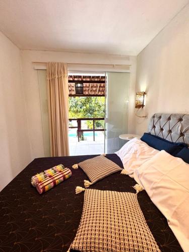 a bedroom with a large bed and a window at Suíte 7 - Village Capixaba in Gravatá