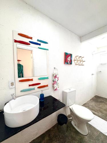 a bathroom with a white toilet and a sink at Suíte 7 - Village Capixaba in Gravatá