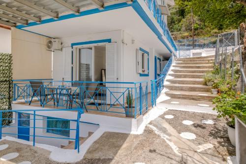 a staircase leading up to a house with blue railing at View of the Ionian Sea, Vournikas in Vournikás