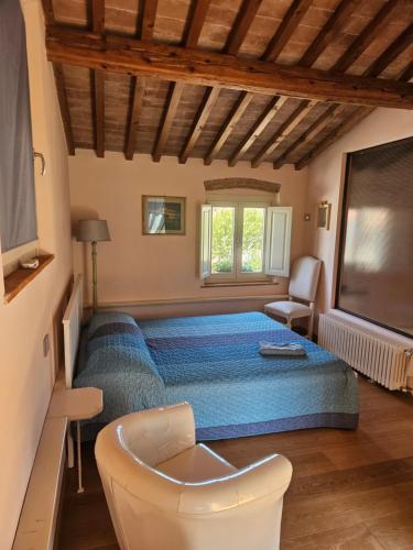 a bedroom with a blue bed and a chair at La Bottega del Maniscalco in Filettole