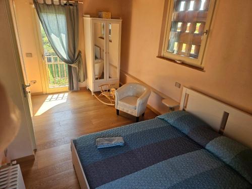 a bedroom with a bed and a chair and a window at La Bottega del Maniscalco in Filettole