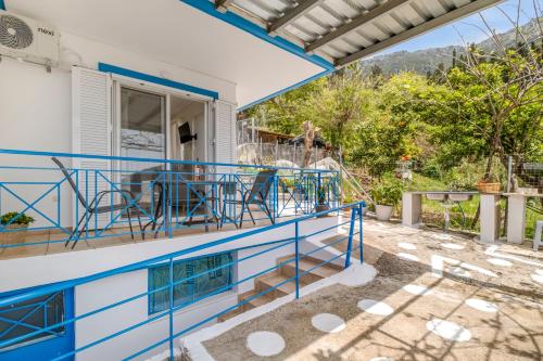 a balcony of a house with blue railing at View of the Ionian Sea, Vournikas in Vournikás