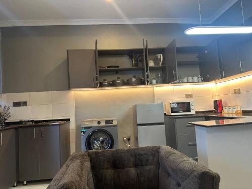 a kitchen with a washing machine in a kitchen at SpeedHome Apartment in Kampala