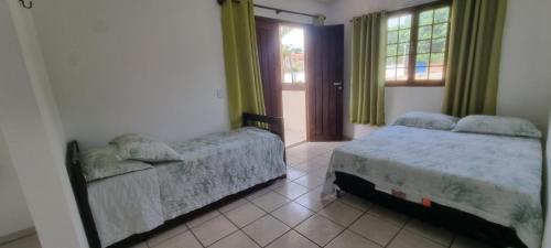 a bedroom with two beds and a window at Casa em Ponta Negra in Natal