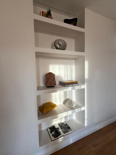 une étagère avec des livres et une horloge dans l'établissement Maison Dalaise - Cannes, à Cannes