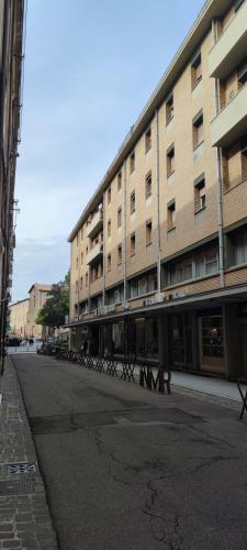 an empty street in front of a large building at Ariminum Suite - Minimalism and class in the historic center in Rimini