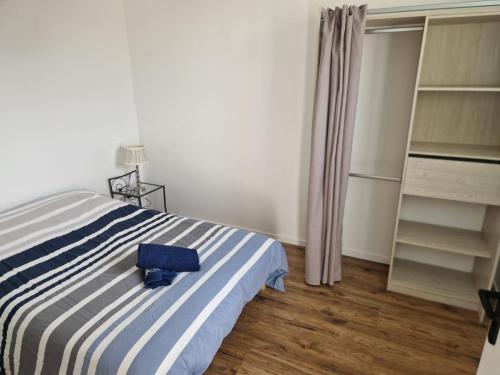 a bedroom with a bed with a blue suitcase on it at Terre&Mer in Lamballe Armor