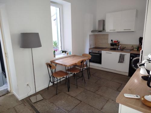 une petite cuisine avec une table et des chaises en bois dans l'établissement Maison de village avec terrasse, à Aubais