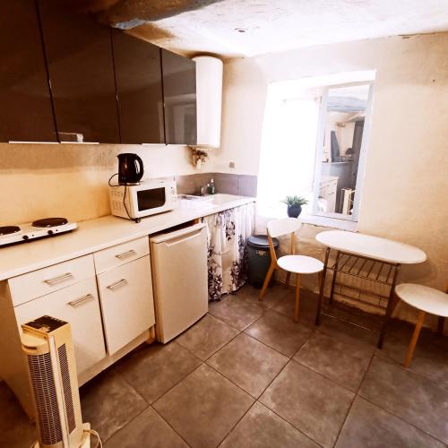 - une cuisine avec un réfrigérateur et deux tabourets dans l'établissement apartement des Romains, à Sospel