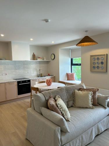 a living room with a couch and a kitchen at The Old Schoolhouse - Castle View in Donegal