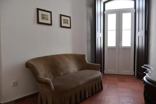 a brown leather chair in a room with a door at Herdade do Vidigal in Montemor-o-Novo