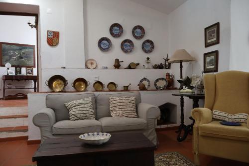 a living room with a couch and plates on the wall at Herdade do Vidigal in Montemor-o-Novo