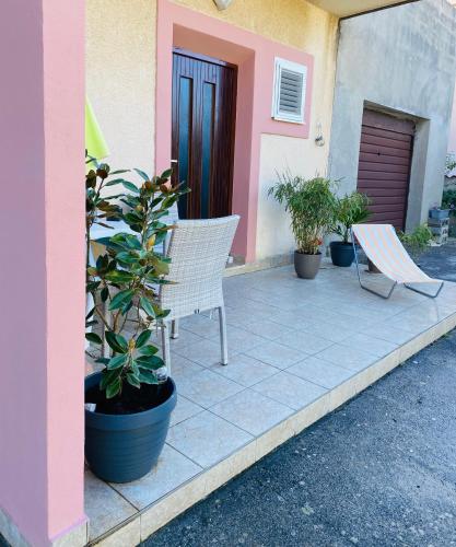 a patio with two chairs and a plant and a door at Apartman Nela in Betina