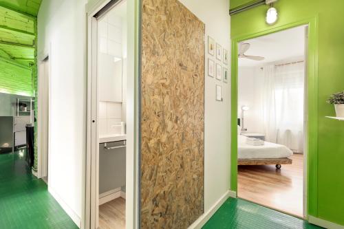 een gang met groene muren en een deur met een spiegel bij Eulalias Lodges Barcelona in Barcelona