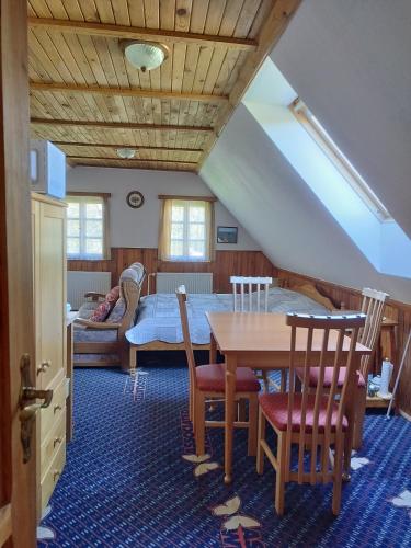 a living room with a table and a bed at Roubenka Mříčná in Mřičná