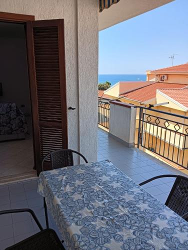 un tavolo e sedie su un balcone con vista di Vincenzo Sea House a Belvedere Marittimo